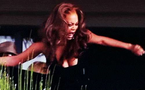 Gif of Tyra Banks aggressively raising both arms, as if in victory